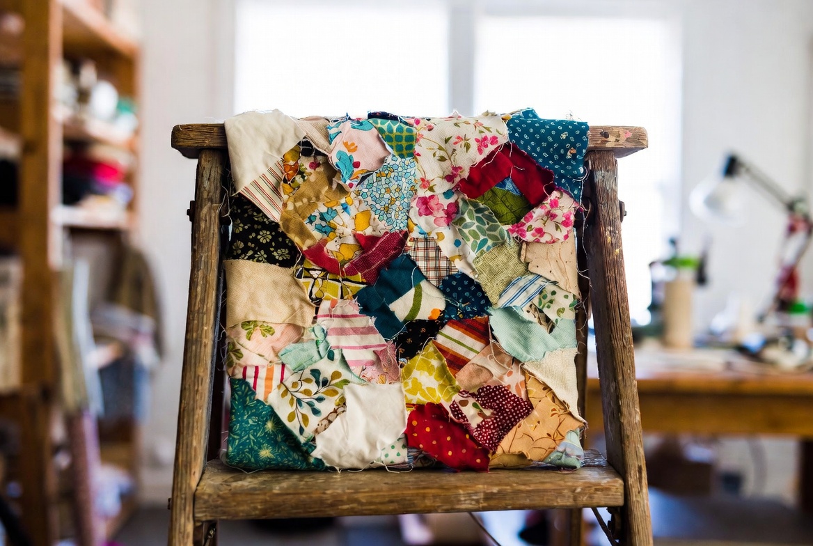 Vibrant scrap quilt on wooden ladder